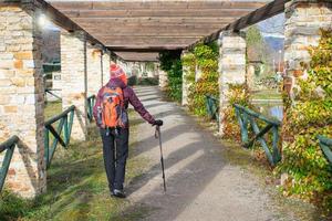 vrouw wandelaar in een park met stenen portieken foto