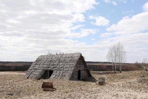 traditioneel oud rustiek gebouw met een dak bedekt met stro op de vroege lentedag, oekraïne. toeristenplaats. foto