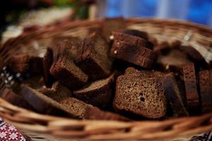 gesneden stukjes zwart brood lagen in een rieten mand. selectieve focus foto