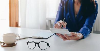 close-up zakenvrouw met behulp van rekenmachine en laptop voor het berekenen van financiën, belastingen, boekhouding, statistiek en analytisch onderzoeksconcept foto