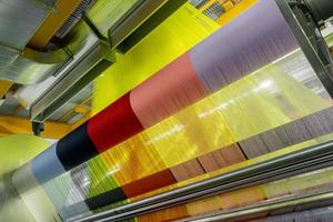 weefgetouw in een textielfabriek, close-up. industriële stoffenproductielijn: foto