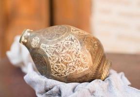 koperen kan met arabisch ornament en gravure. handmatig koper slaan foto