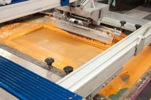 apparatuur en machines om doek te schilderen bij een close-up van een kledingfabriek foto