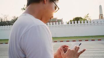 reiziger aziatische man richting op locatiekaart in bangkok, thailand, backpacker man die mobiele telefoon gebruikt die op de kaart kijkt terwijl hij een vakantiereis doorbrengt bij zonsondergang. levensstijl mannen reizen in azië stadsconcept. foto