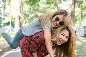 gelukkige jonge aziatische vrouwen spelen met elkaar terwijl ze een stedentrip maken in een warm zonlicht ochtendweekend. stad en natuur levensstijl van jonge vrouwen. levensstijl in het concept van de stadsactiviteit. foto