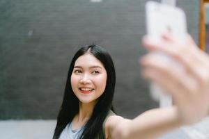 aziatische bloggervrouw reist in beijing, china, backpackervrouw die mobiele telefoon gebruikt, maakt vlog en leeft op sociale media terwijl ze leuke tijd doorbrengt tijdens een vakantiereis. vrouwen reizen in stadsconcept. foto