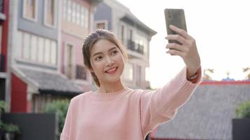 vrolijke mooie jonge Aziatische backpacker blogger vrouw met behulp van smartphone selfie te nemen tijdens het reizen in Chinatown in Peking, China. levensstijl rugzak toeristische reizen vakantie concept. foto