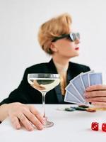 volwassen stijlvolle vrouw in zwarte smoking en zonnebril in casino. gokken, mode, pokerface, hobbyconcept. foto