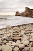 piramide stenen aan de kust op een zonnige dag op de achtergrond van de blauwe zee. fijne vakantie. kiezelstrand, kalme zee, reisbestemming. concept van gelukkige vakantie aan zee. foto