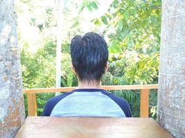 achteraanzicht van het haar van een man tegen de achtergrond van bomen foto
