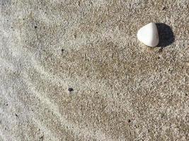 achtergrond met zand en eenzame steen foto