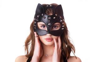 leer, elegant, zwart masker van de kat op jong vrouwelijk model op witte achtergrond. isoleren. close-up, portret foto