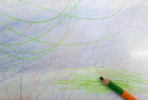 kleur potloden met getekende gekleurde lijnen geïsoleerd op een witte achtergrond. bovenaanzicht. met de hand getekende krabbelvegen op papier foto
