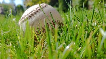 witte oude honkbal op vers groen gras met kopie ruimte close-up. Amerikaans sporthonkbalspel. foto