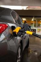 auto vullen met benzine bij benzinestation auto tanken brandstof op benzinestation. foto