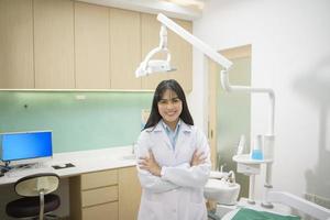 portret van vrouwelijke tandarts die in de tandheelkundige kliniek werkt, tandencontrole en gezond gebit concept foto