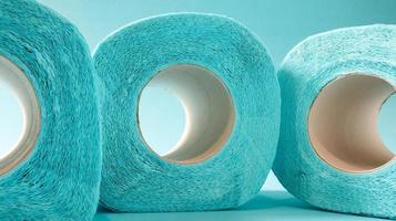 blauwe rol modern toiletpapier op een blauwe achtergrond. een papieren product op een kartonnen hoes, gebruikt voor sanitaire doeleinden van cellulose met uitsparingen om gemakkelijk te scheuren. reliëf tekening foto