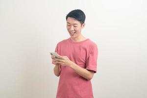 jonge aziatische man die smartphone en mobiele telefoon gebruikt of praat met een blij gezicht foto