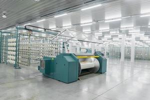 textielgaren op de wikkelmachine wordt op de grote as geschroefd. machines en uitrusting in een textielfabriek foto
