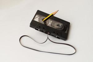 vintage audiocassetteband met een potlood in het gat om de buitenband terug te spoelen. technologie uit de jaren 90. foto