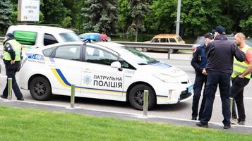 oekraïne, kiev - 2 juni 2020. politiepatrouillewagens zorgen voor veiligheid op de wegen van kiev in oekraïne. een mannelijke politieagent staat bij zijn auto op de rijbaan foto