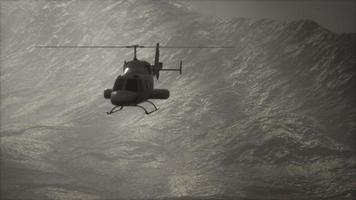 extreme slow motion vliegende helikopter in de buurt van bergen met mist foto