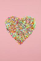 hartvorm gemaakt van papieren confetti. valentijnskaart Valentijnsdag, hart silhouet roze achtergrond foto