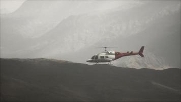 extreme slow motion vliegende helikopter in de buurt van bergen met mist foto