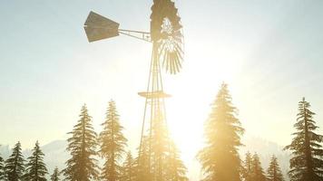 typische oude windmolenturbine in bos bij zonsondergang foto