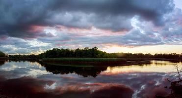 prachtige zonsopgang met heldere wolken weerspiegeld in water foto