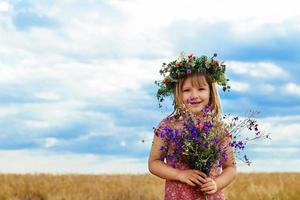 schattig klein meisje in zomertarweveld foto