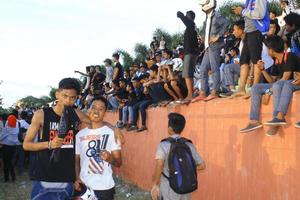 gorontalo-indonesia, maart 2015 - voetbalfans van beroepsscholen juichen hun favoriete team toe vanaf de tribune foto