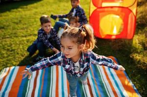 vier kinderen die tijd samen doorbrengen. picknickdeken voor buiten. foto