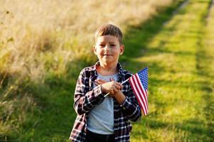 kleine jongen met usa vlag buiten. Amerika vieren. hand op het hart. foto