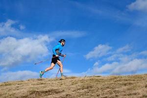 uithoudingsrace in de bergen. een man met klimstokken foto