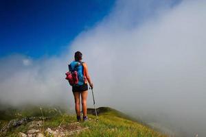 een meisje kijkt tijdens een wandeling in de verte in de mist naar de bergvallei foto