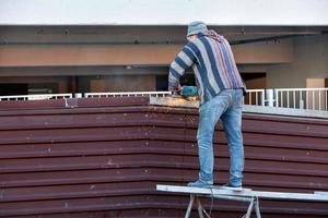 31.08.2021. kiev. Oekraïne. een arbeider slaat heldere vonken terwijl hij met een slijpmachine werkt en een metalen hek installeert. foto