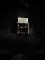 parfumflesje op zwarte stof foto