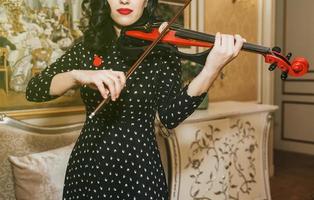 vrouw met rode lippen die viool speelt foto