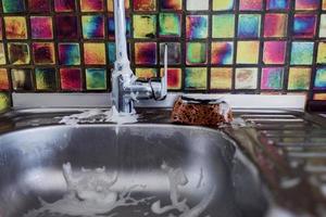 de keukenkraan en metalen gootsteen wassen foto