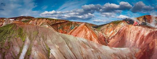 prachtig panoramisch IJslands landschap van kleurrijke regenboog vulkanische landmannalaugar-bergen, op het beroemde laugavegur-wandelpad met dramatische besneeuwde lucht en rode vulkaanbodem in ijsland. foto