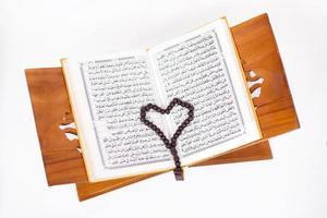 hou van het heilige boek koran en tasbih geïsoleerd op een witte achtergrond foto