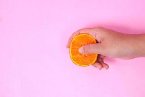 seksuele voorlichting met sinaasappelen geïsoleerd op roze achtergrond foto