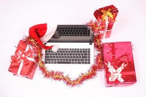 laptop en gitf-doos voor kerstmis en nieuwjaarsviering geïsoleerd op een witte achtergrond foto