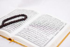 verzen van de heilige koran en tasbih geïsoleerd op witte achtergrond foto