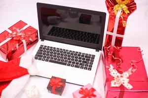 laptop en gitf-doos voor kerstmis en nieuwjaarsviering geïsoleerd op een witte achtergrond foto