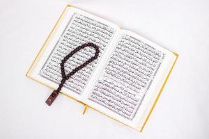 verzen van de heilige koran en tasbih geïsoleerd op witte achtergrond foto