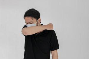 zieke aziatische man griep en hoest zit met het gebruik van een masker. ziekte, griep, pijnconcept. zorg en corona concepten foto