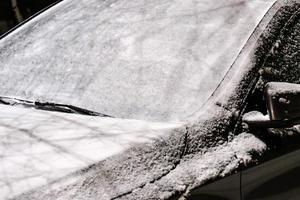 auto voorruit bedekt met een dikke laag sneeuw na storm buiten foto