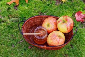 honing in een glazen pot met bloemen, honingzoete kruiden en herfstappels foto